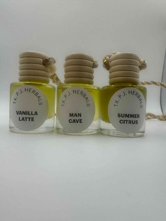Set of three all natural car air fresheners in vanilla latte, man cave, and summer citrus scents with wooden lids and essential oils.
